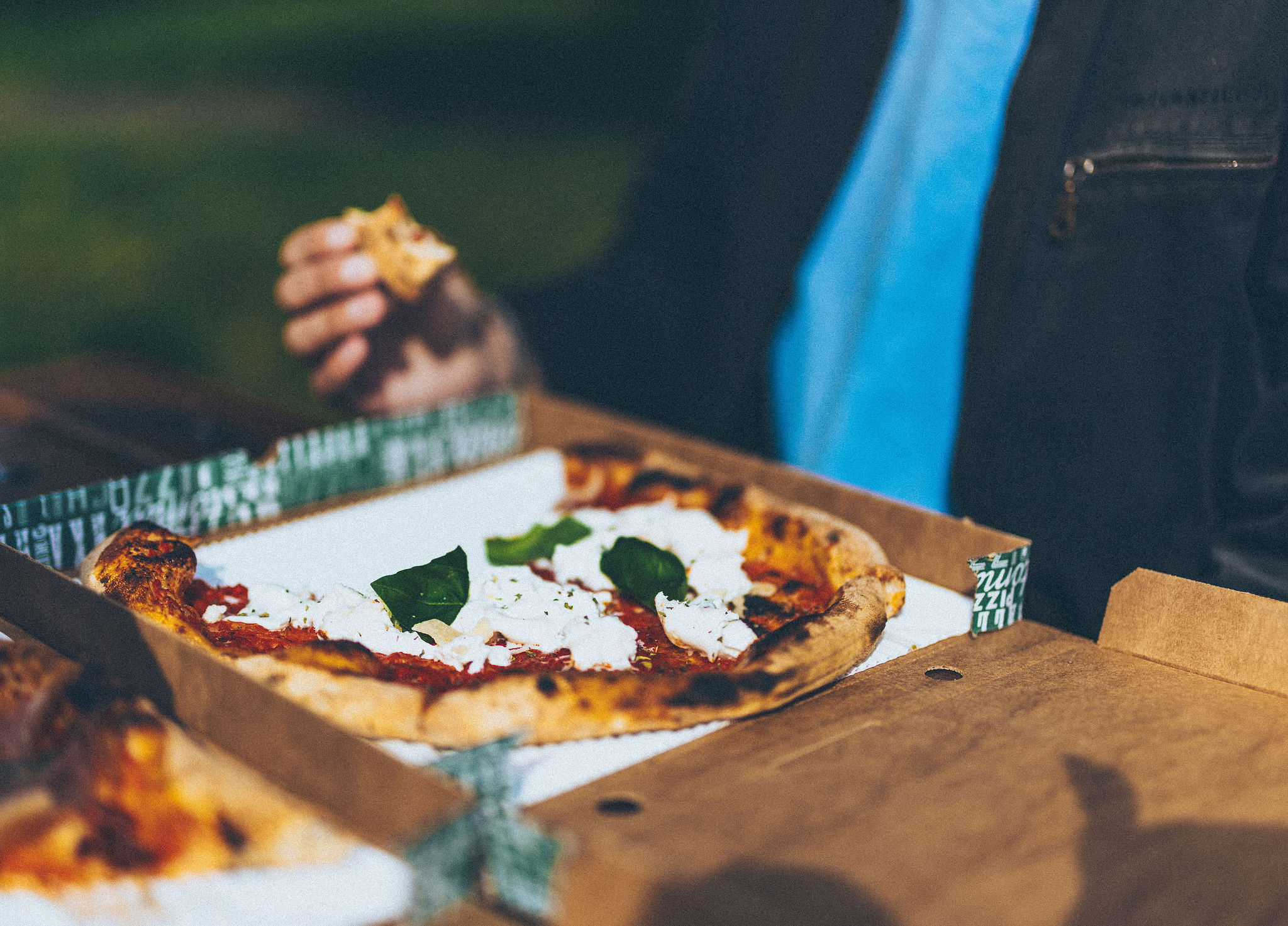 Gäster äter pizza från Kuben utomhus